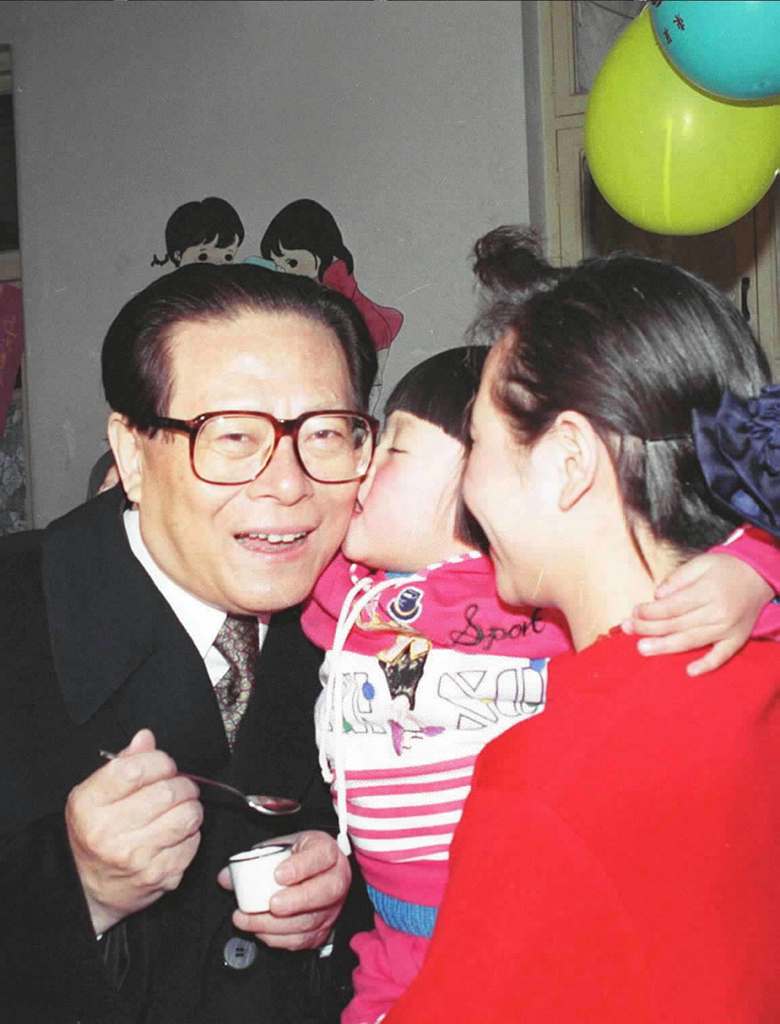 1993年12月5日，江泽民同志在北京为一位幼儿园儿童喂服脊髓灰质炎疫苗后，小朋友亲吻江爷爷。